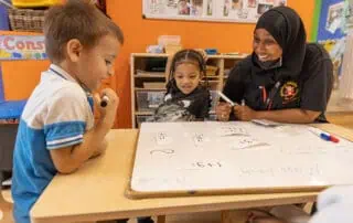 nursery children learning with staff